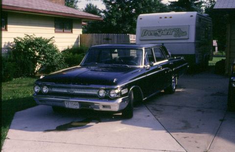 1988 Ford Bronco - Dark 1961 Mercury Monterey sedan parked in a driveway with a trailer in the background.