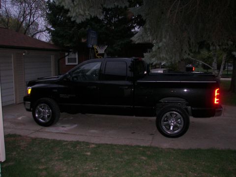 1988 Ford Bronco - A black pickup truck is parked in a driveway with a house and trees in the background.