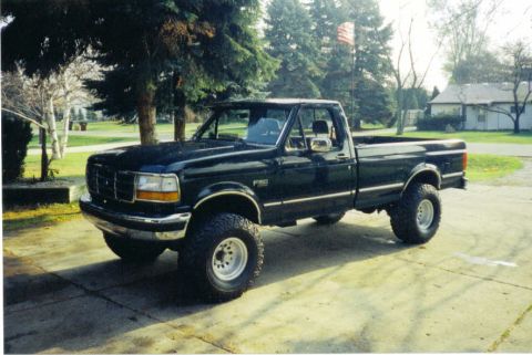 1988 Ford Bronco - This black pickup truck, likely a 1995 model, is shown from a 3q front angle.