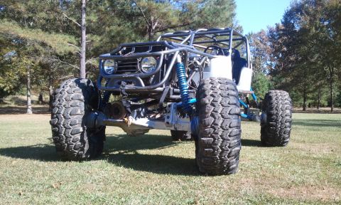 1967 Ford Mustang - A custom-built buggy with a prominent roll cage and oversized tires is parked outdoors on a sunny day.