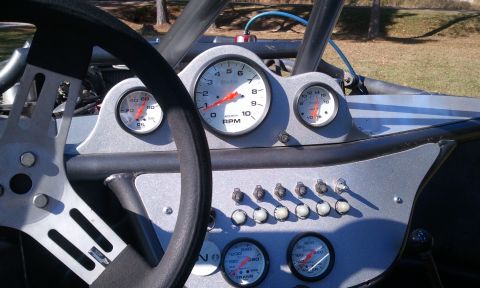 1967 Ford Mustang - The interior of a custom buggy features a dashboard with multiple gauges and switches.