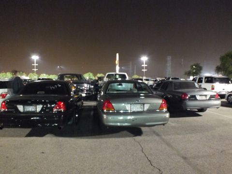 2003 Ford Crown Victoria - Crown Victoria sedans clustered in a floodlit parking lot, one window marked 1572 in white