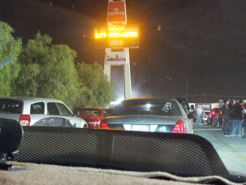 2003 Ford Crown Victoria - View across a car dash to a gray Crown Victoria and the glowing Irwindale pylon sign at night