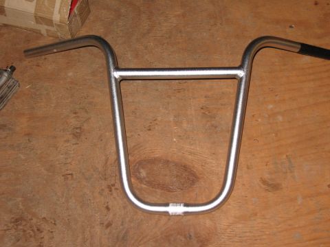 1994 Ford Bronco - A close-up view of silver bicycle handlebars resting on a wooden surface.