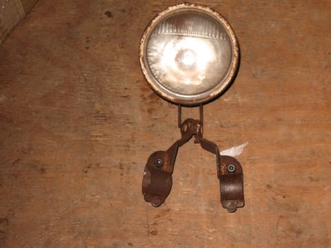 1994 Ford Bronco - This old headlight assembly is mounted on a wooden surface.