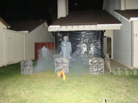 1989 Ford Bronco - A spooky Halloween display features tombstones, fog, and ghost figures on a residential lawn.