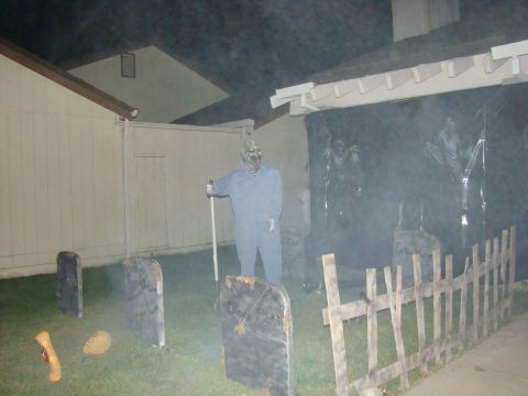 1989 Ford Bronco - A yard decorated for Halloween with a zombie figure and tombstones, shrouded in fog.