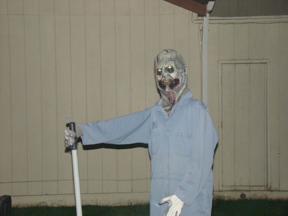 zombie decoration in light blue overalls holding a pole