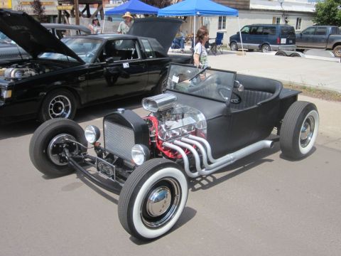 1991 Ford LTD Crown Victoria - A black hot rod is parked next to a black Buick Regal at an outdoor car show.