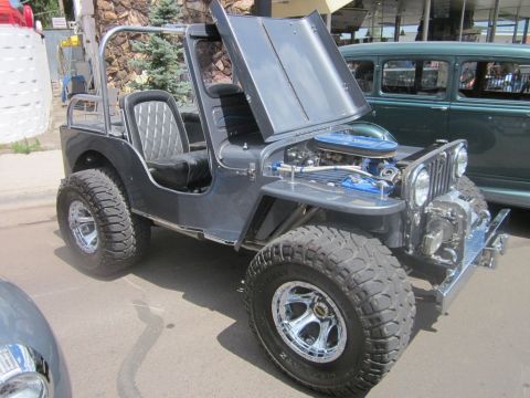 1991 Ford LTD Crown Victoria - A modified Jeep CJ is displayed with its hood open, revealing the engine compartment.