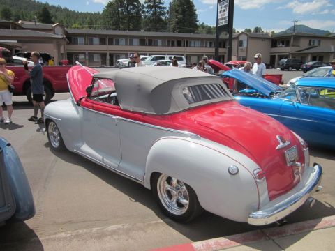 1991 Ford LTD Crown Victoria - A two-tone convertible is displayed at an outdoor car show with other vehicles present.