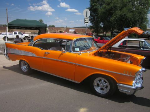 1991 Ford LTD Crown Victoria - This orange 1957 Chevrolet Bel Air coupe was displayed with its hood open at a car show.