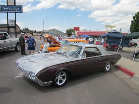 1991 Ford LTD Crown Victoria - A classic two-tone coupe is displayed at an outdoor car show with other vehicles and attendees.