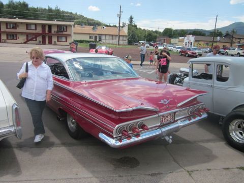 1991 Ford LTD Crown Victoria - A classic red and white Chevrolet Impala is parked at an outdoor car show.
