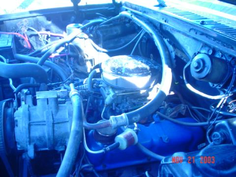 1986 Ford Bronco - Close-up view of an engine bay, showing the carburetor and air filter assembly.