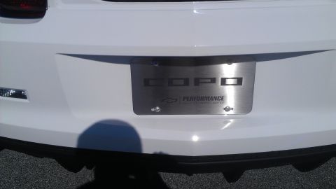 1973 Chevrolet Camaro - Rear view of a white car a COPO Performance license plate frame and Supermotors.net branding.