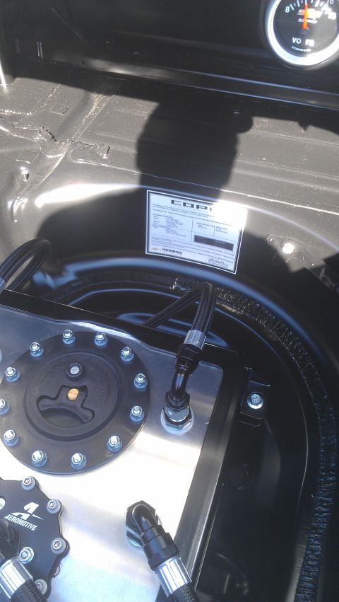 1973 Chevrolet Camaro - A close-up view of a fuel cell and a gauge, likely in a vehicle's trunk or engine bay.