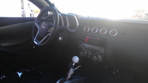 1973 Chevrolet Camaro - Interior view of a car with custom gauges and a floor shifter.