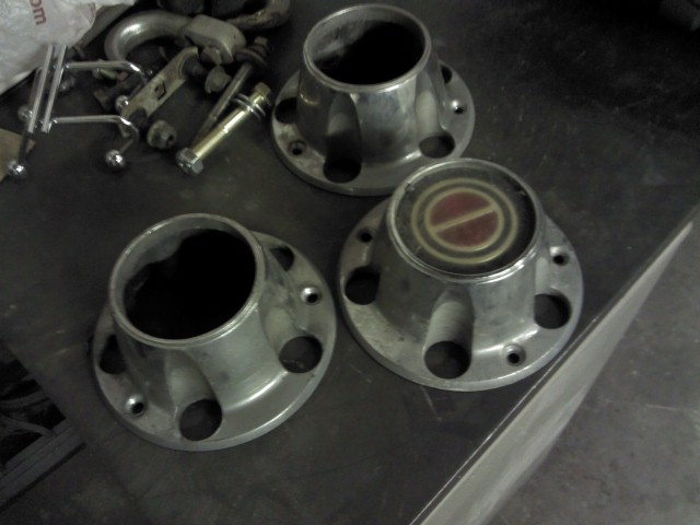 Three metal hubcaps with red and gold emblems
