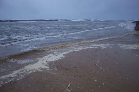 1990 Ford Bronco - A stormy beach scene with waves crashing ashore, indicating rough weather conditions.