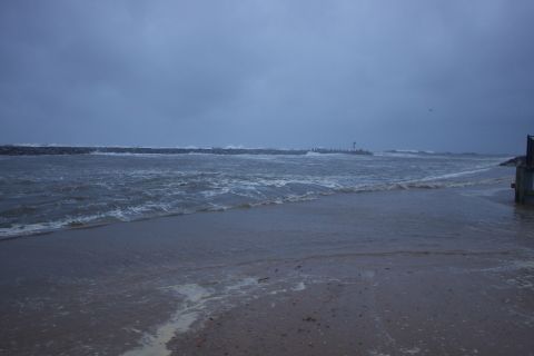 1990 Ford Bronco - A stormy day at the beach with rough waves and a distant lighthouse.