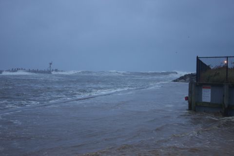 1990 Ford Bronco - Ocean scene during a storm with large waves and flooding near a pier.