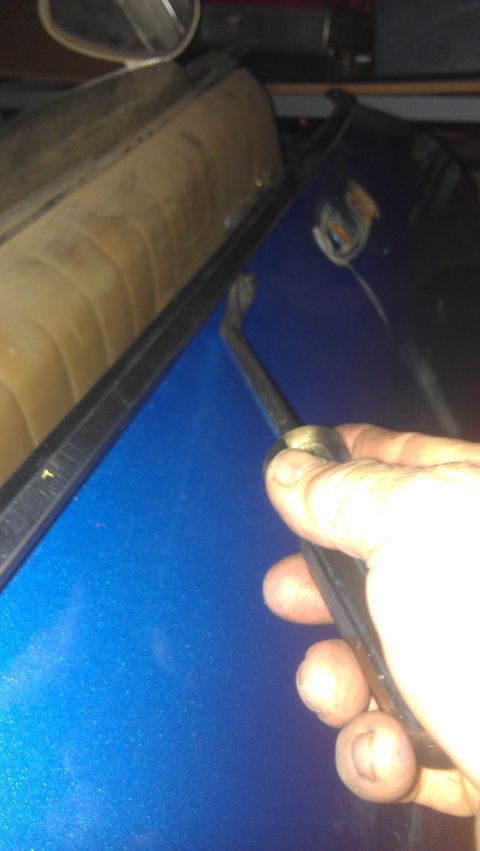 1973 Chevrolet Camaro - Using a trim removal tool on the door panel of a car.