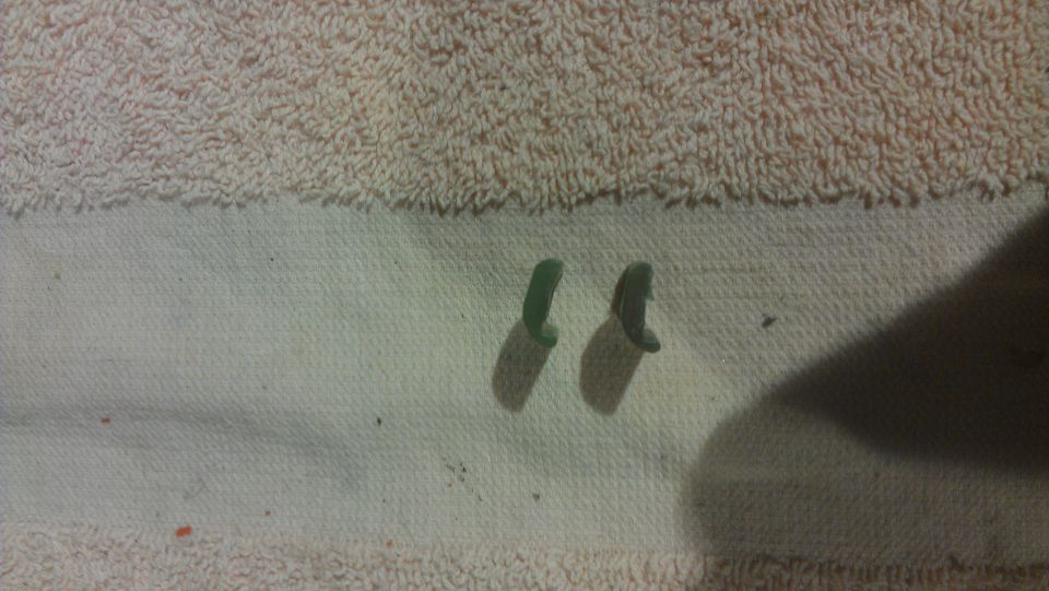 Two green plastic clips on a white cloth