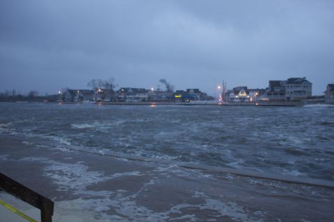 1990 Ford Bronco - Coastal town experiencing flooding with rough water and overcast skies.