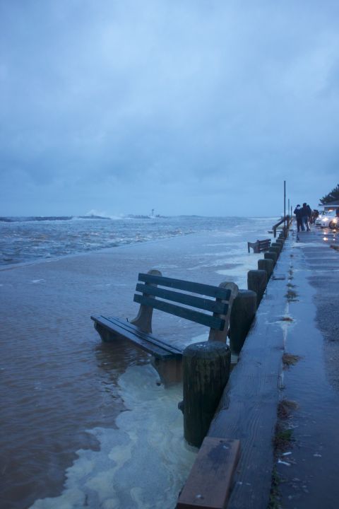 1990 Ford Bronco - A bench sits in floodwaters on a boardwalk next to the ocean during a storm.