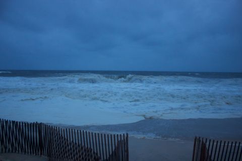 1990 Ford Bronco - Ocean waves during a storm, with a wooden fence on the beach. Supermotors.net logo visible.