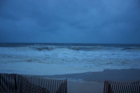 1990 Ford Bronco - Rough seas and choppy waves batter the shore under a gloomy, overcast sky.