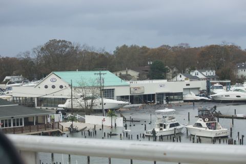 1990 Ford Bronco - Boats are docked at a marina, with some pulled onto land near buildings after an event.