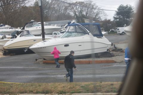 1990 Ford Bronco - Boats are stored on land, possibly after a storm, with people nearby.