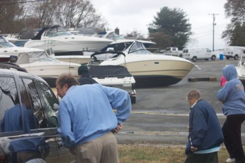 1990 Ford Bronco - Boats are stored on land with people nearby, under an overcast sky.