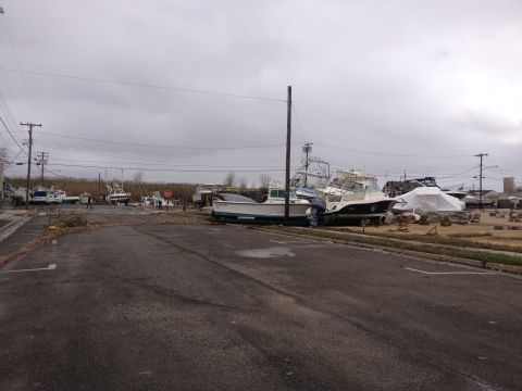 1990 Ford Bronco - A scene of destruction shows multiple boats displaced onto land following a major storm event.