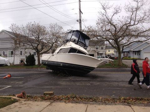 1990 Ford Bronco - A boat is on a residential street, possibly after a storm, leaning against a utility pole.