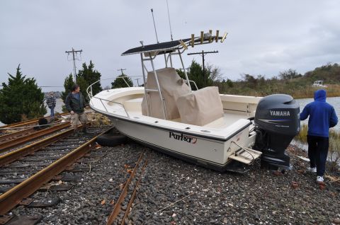 1990 Ford Bronco - A boat has been moved onto train tracks, with two people observing the unusual situation.