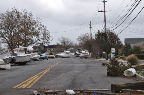 1990 Ford Bronco - Multiple boats are displaced onto a street, likely due to severe weather conditions.