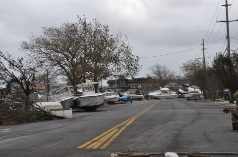 1990 Ford Bronco - Several boats have been displaced onto a street, likely due to severe weather conditions.
