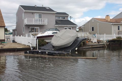 1990 Ford Bronco - Boats on a dock after a storm, with houses visible behind them.