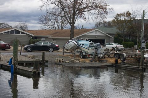 1990 Ford Bronco - A boat on a trailer is tilted precariously, with residential buildings and other vehicles visible in the background.