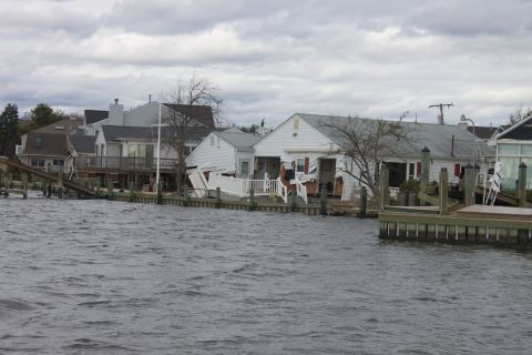 1990 Ford Bronco - Flooded waterfront properties show damage to docks and homes after a storm.