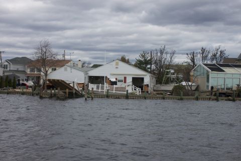 1990 Ford Bronco - Flooded waterfront properties show the aftermath of a storm, with a boat partially obscured.