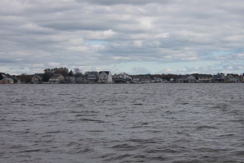 1990 Ford Bronco - A row of houses lines the shore across a body of choppy water under a cloudy sky.