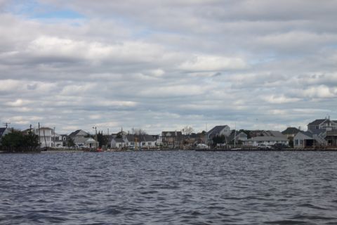 1990 Ford Bronco - A view of waterfront houses under a cloudy sky, taken from the water.