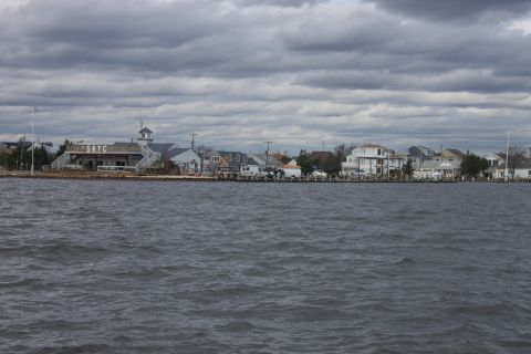 1990 Ford Bronco - A view of waterfront buildings and a cloudy sky over choppy water.
