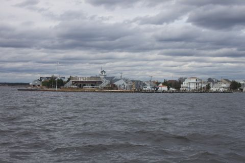 1990 Ford Bronco - A view of waterfront buildings and houses from the water under a cloudy sky.