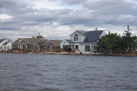 1990 Ford Bronco - Waterfront homes show damage from a storm, with some properties solar panels on their roofs.
