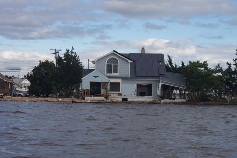 1990 Ford Bronco - House damaged by flooding, with solar panels installed on the roof.